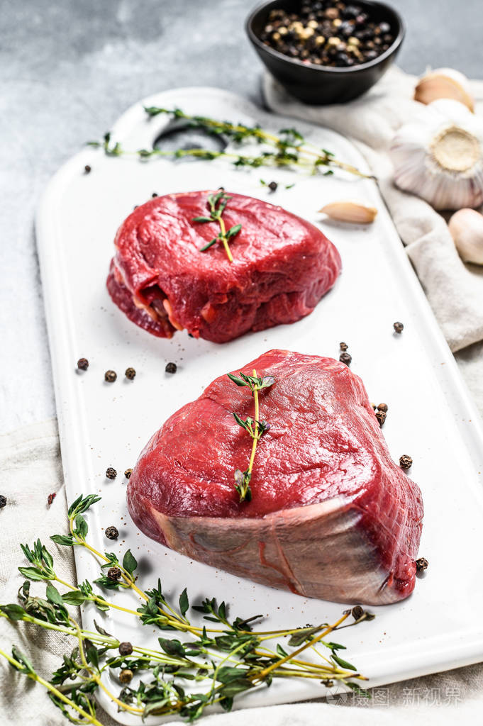 大理石牛肉里脊白菜板上的生菲力牛排灰色背景俯视图