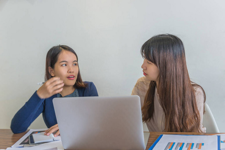 Two young females having business discussion at modern  pl