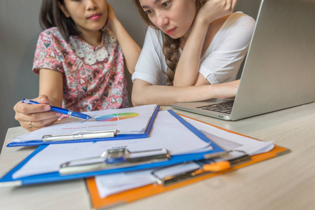 Woman looking at point showing on chart data document 