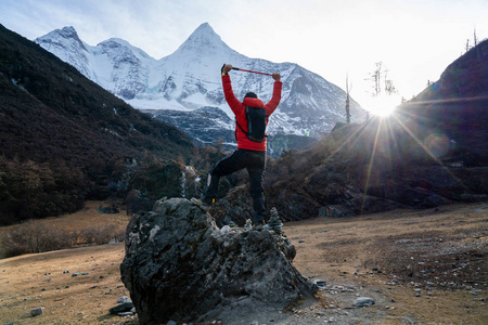 Male trekking standing on the stone and snow mountain front 