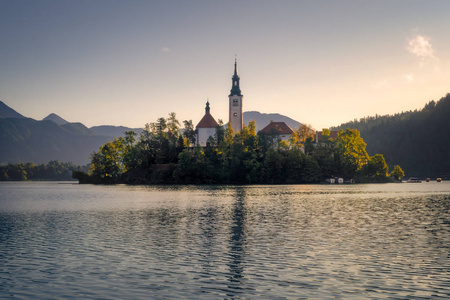 Scenic view of Lake Bled island with church and colorful autumn 