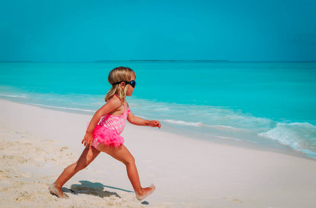小女孩在沙滩上跑去游泳，孩子们在享受大海