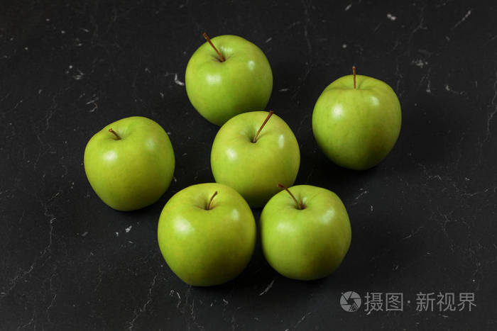 黑色大理石板上有六个绿黄苹果