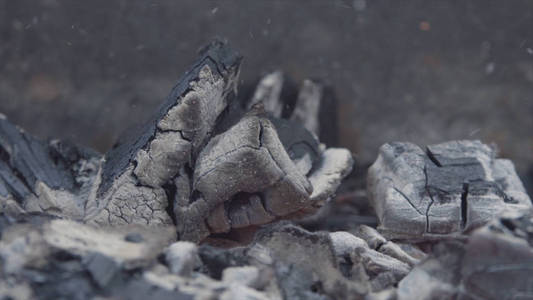 行动.大块的木头在灰烬和灰烬中燃烧着红黄色的火焰.照片