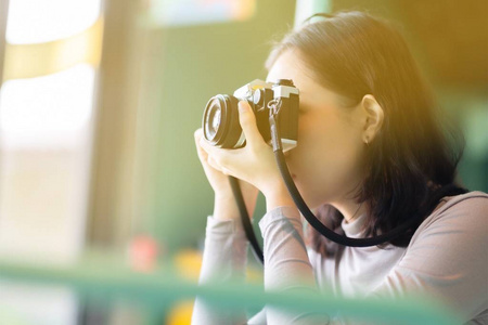 Asian woman photographer take a picture by film camera 