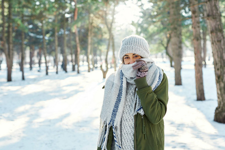 冬季户外写真雪地公园快乐女孩感觉寒冷和羊毛围巾覆盖脸