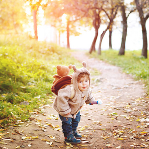 Cute funny toddler in autumn park walking 