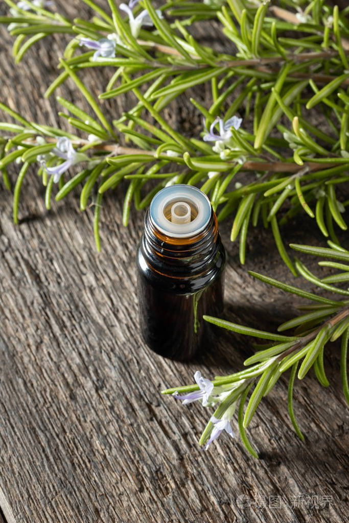 一瓶深色迷迭香精油和新鲜迷迭香