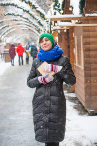 The girl is holding a box with a gift. 