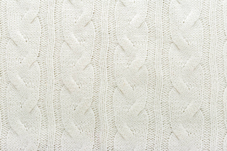 米色针织物羊毛质地为背景。白色针织物图案的特写设计。米色保暖毛衣织物背景。