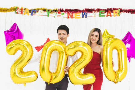 年轻夫妇一起庆祝新年，手持2020年气球