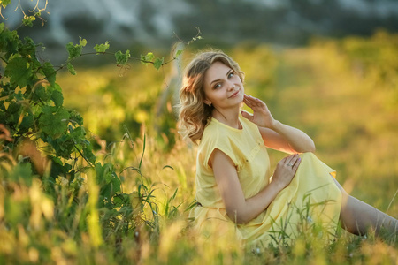 一位穿着黄色复古连衣裙的娇嫩女孩在火热的秋日自然背景下漫步。艺术摄影