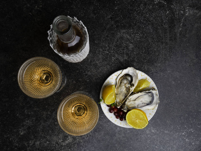 冰鲜牡蛎配葡萄酒或香槟瓶，柠檬，蔓越莓。食物背景