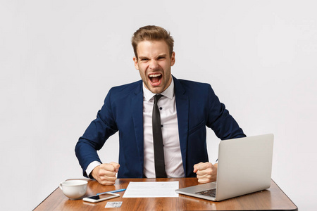 富于表现力和愤怒的年轻金发商人大肆敲打桌子,大声喊着生意伙伴,对
