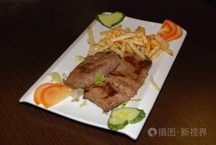 friedbeeffilletwithfrenchfriesandfreshvegetablesonthe