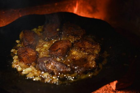 在火里煎的肉排。潘也在煮肉