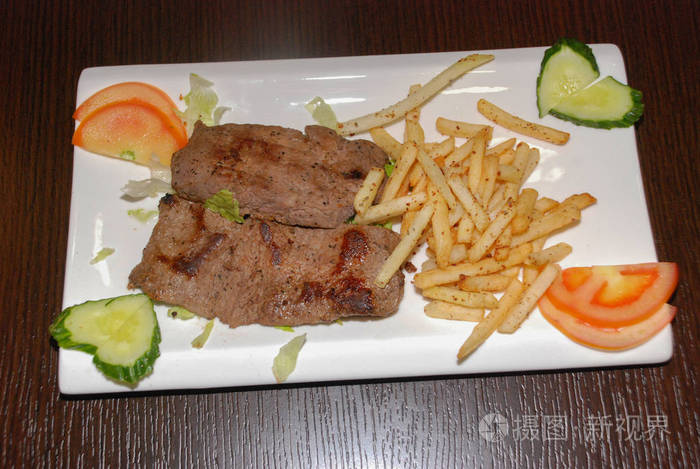 friedbeeffilletwithfrenchfriesandfreshvegetablesonthe