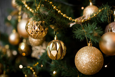 美丽的圣诞树，装饰着金色的玩具和带礼物的灯。新年内饰