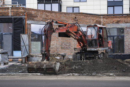 奥兰治挖掘机在施工现场用碎石把它从一个地方运到另一个地方。重工业。建筑物的建造。