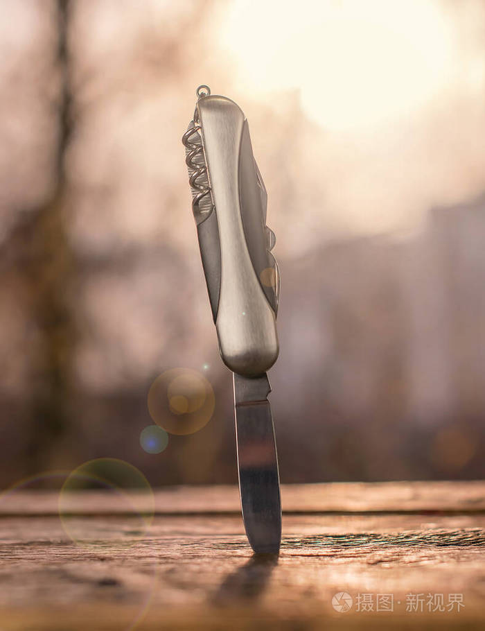 在夕阳余晖的背景下刀子卡在木板上