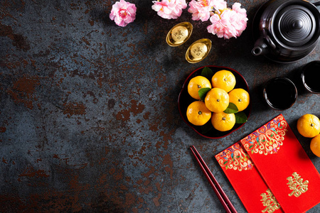 中国的春节装饰波或红包，橙色和金锭或黄金块在黑色石头纹理的背景。汉字福的意思是好运好运财富金钱流动。