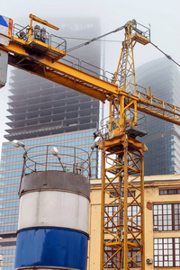 在一个废弃的建筑工地上，一座正在建造的摩天大楼的背景上的起重机