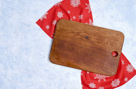 Empty kitchen cutting board with red christmas tablecloth. View 