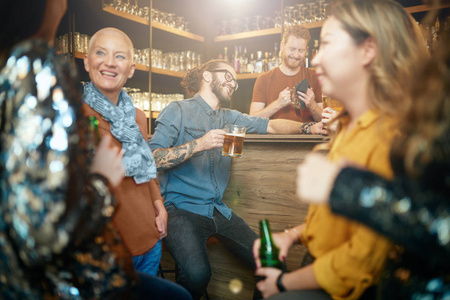 一群朋友聊天，喝啤酒，在酒吧玩得很开心。