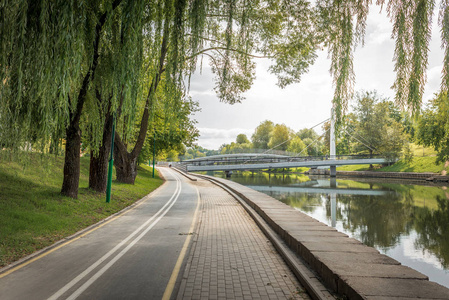 公园里的自行车道沿河绿树成荫。美丽