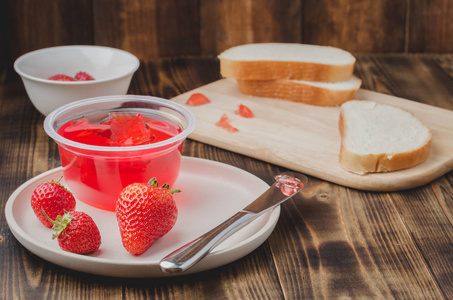 Strawberry jam. Bread and strawberry jam on a wooden table with 