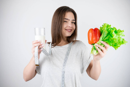 年轻微笑的女人脖子上围着厘米，手里拿着一杯开菲尔红辣椒和新鲜沙拉隔离的白色背景营养学和营养