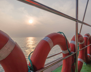一艘游艇上的救生圈顶着晨曦，在平静的海水中反射，斯里兰卡