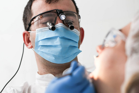 男牙医检查病人的牙齿。选择性聚焦