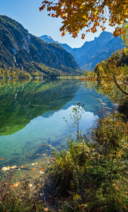 Peaceful autumn Alps mountain lake with clear transparent water 