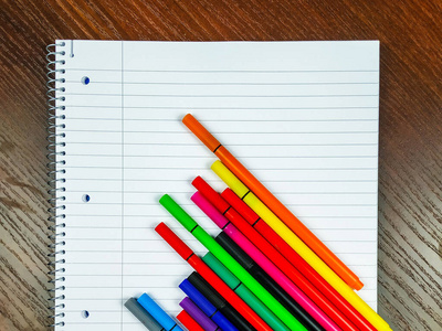 Empty white notebook with lines and colorful pens on top for tak