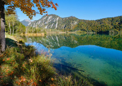 Peaceful autumn Alps mountain lake with clear transparent water 