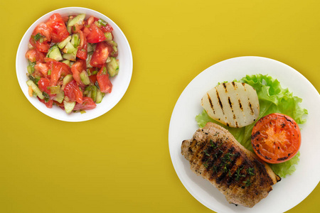  grilled pork with potatoes and tomatoes on a colored background