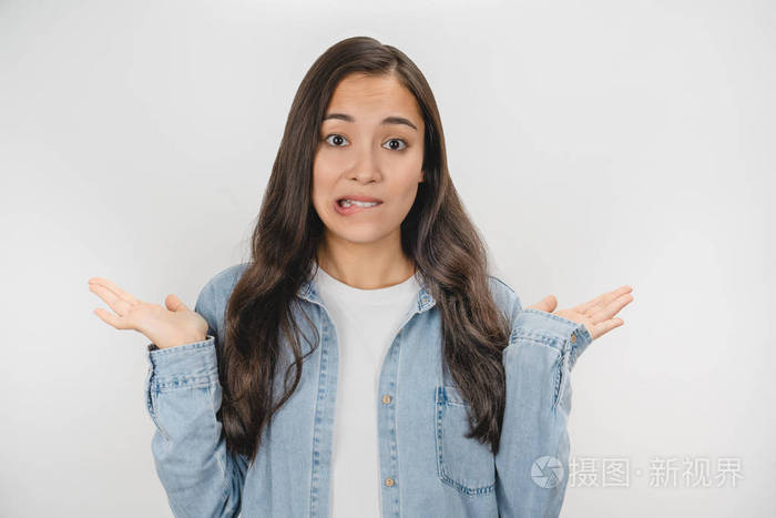 一幅亚洲犹豫不决的女人耸耸肩将手扔到一边的画像背景为白色