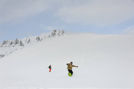 两个滑雪板运动员从山顶滑翔