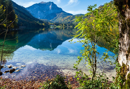 Peaceful autumn Alps mountain lake with clear transparent water 