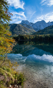 Peaceful autumn Alps mountain lake with clear transparent water 