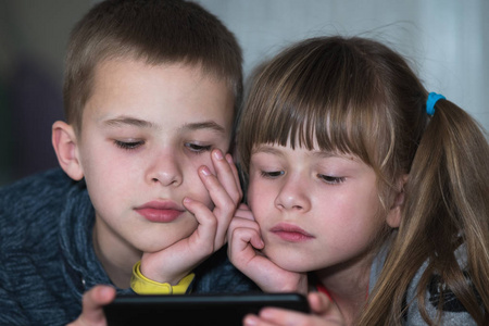 两个孩子兄妹在智能手机scr上看视频