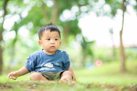 可爱的婴儿，蹒跚学步的小男孩在绿色公园玩耍