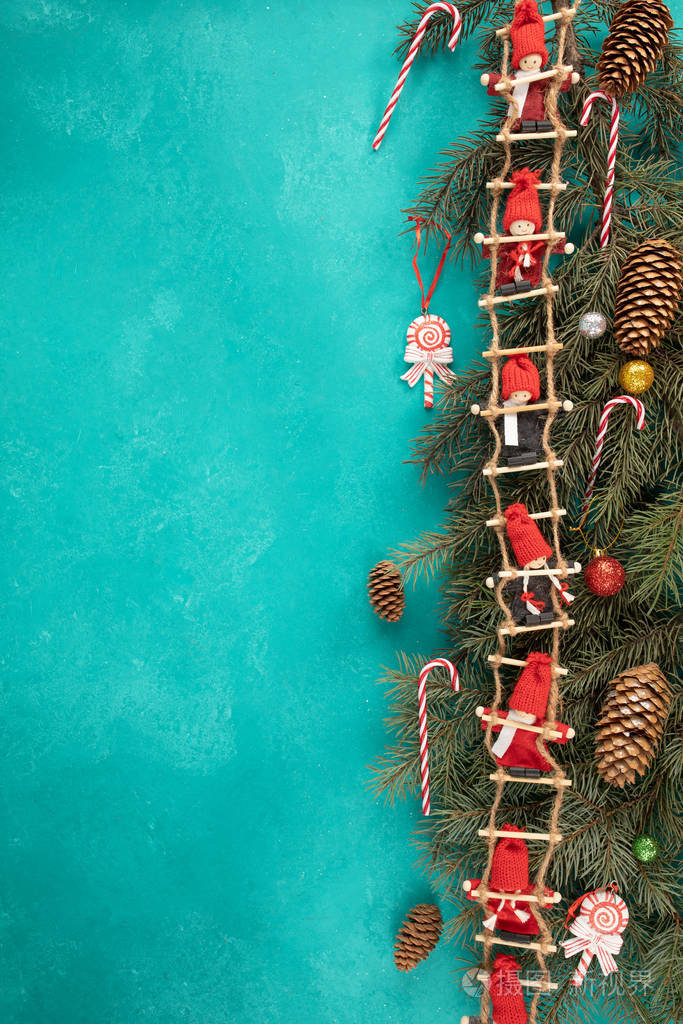 圣诞背景有圣诞树的树枝蓝色背景上有一个红色娃娃的花环文本的俯视图