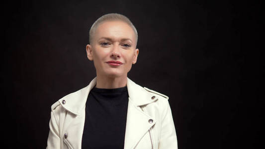  blond woman with short hair on a black background in a white le