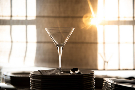 Empty glass cup with sun flares background in a restaurant.