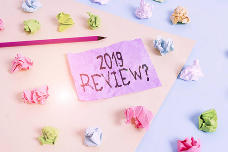 写明2019年复习题的笔记。商业照片展示回忆过去一年的事件主要行动或良好显示彩色皱折纸空提醒蓝黄色衣夹。
