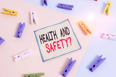 概念性手写体，显示健康和安全问题。展示防止事故或伤害的规章制度和程序的商业照片黄蓝色背景色衣夹纸提醒