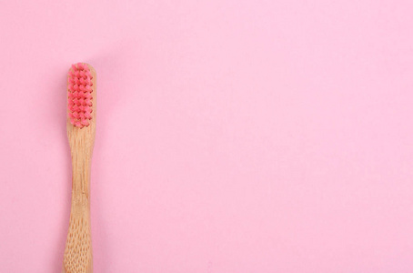 粉红色背景竹制牙刷，顶视图。空间fo