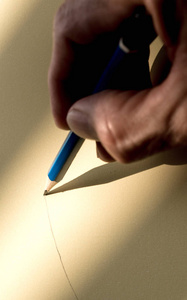 人的手拿着铅笔在纸上写字